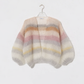 Multicolored striped sweater on a hanger against a white background