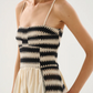 A lightweight midi dress crafted from 100% knitted cotton. Thin, adjustable straps and a smocked back ensure a comfortable fit, while the flowing cotton skirt drapes effortlessly. Finished with delicate contrast stitching along the hem, blending artisanal detail with a modern silhouette.


100% Cotton.

fitting advice - Slim fit.