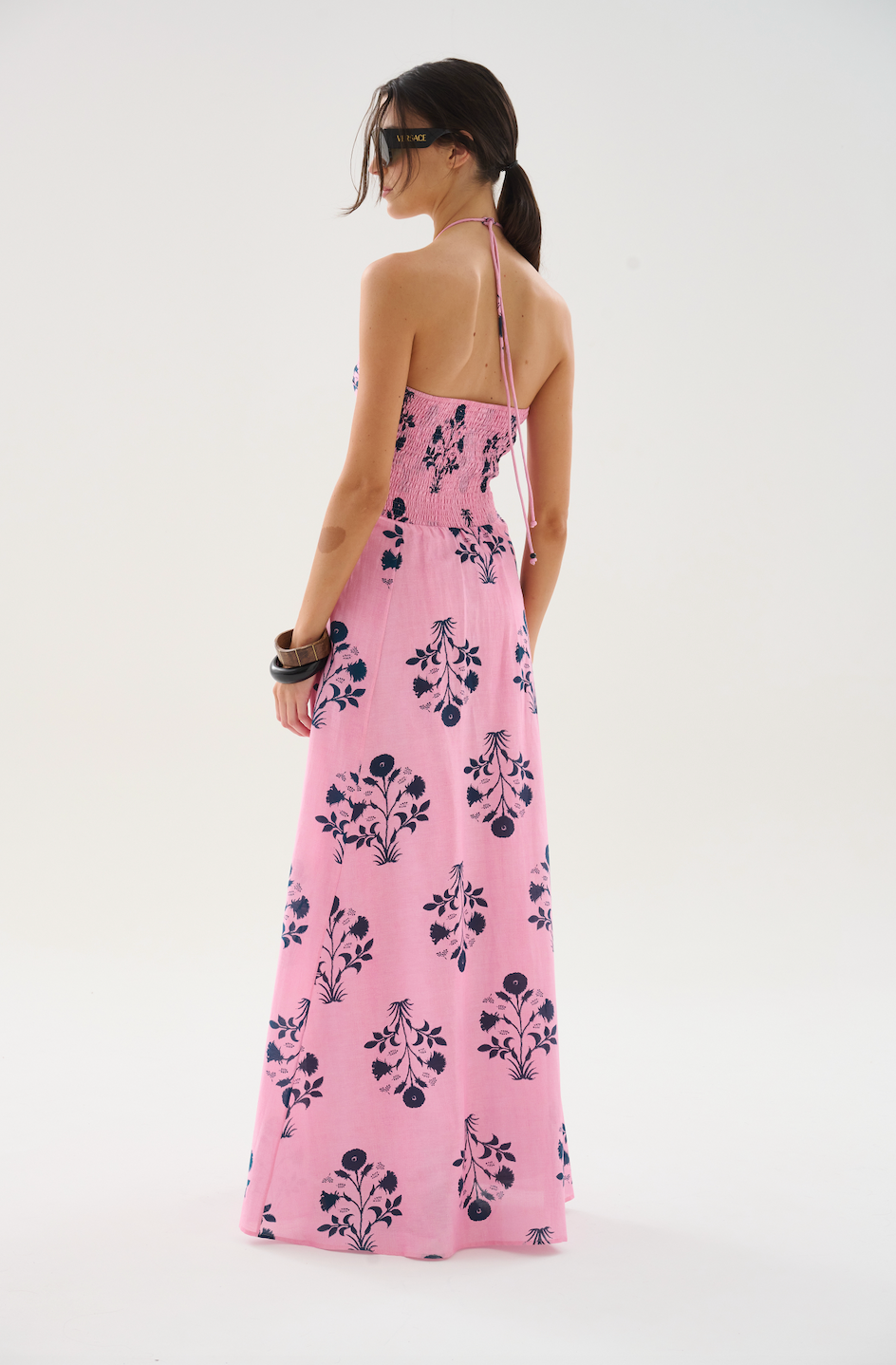Woman wearing a pink floral dress on a white background