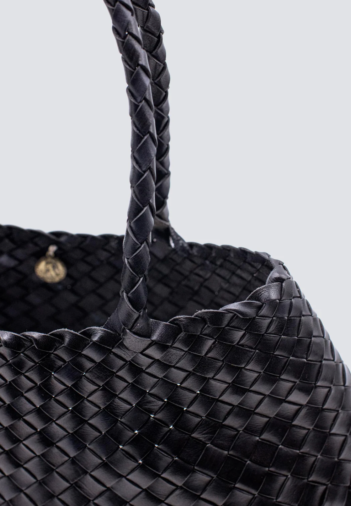 The Santa Croce bag is formed of irregular leather weaving straps that taper towards the brim, creating a practical yet elegant shape that’s perfect for running around the city—taking your outfit from day to night. Remaining true to traditional basket weaving techniques, the Santa Croce comes unlined and has an open top.

An antiqued St. Christopher medal charm, in homage to the patron saint of travellers, is hand-sewn inside each and every Dragon Diffusion bag—our brand’s very own seal of authenticity.