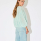 Maiami’s iconic mohair bomber cardigan, defined by its airy volume and signature fluffy texture. Knitted from a soft mohair blend, the cardigan features a relaxed silhouette with gently rounded sleeves and an open front. The lightweight yet warm knit creates a cloud-like feel, while the tactile surface and effortless shape make it a distinctive everyday luxury piece.