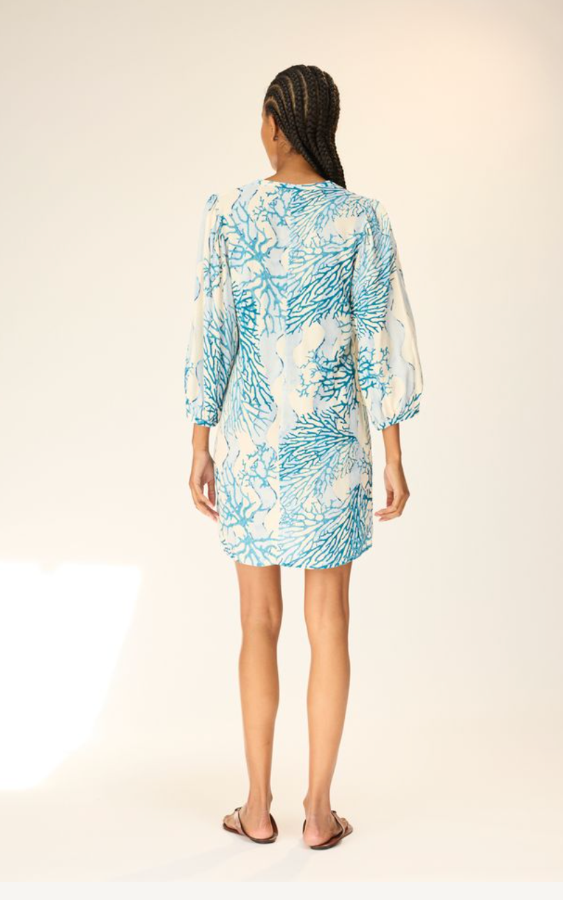 Woman wearing a blue floral dress on a white background