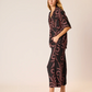 Woman wearing a black and red patterned outfit on a white background