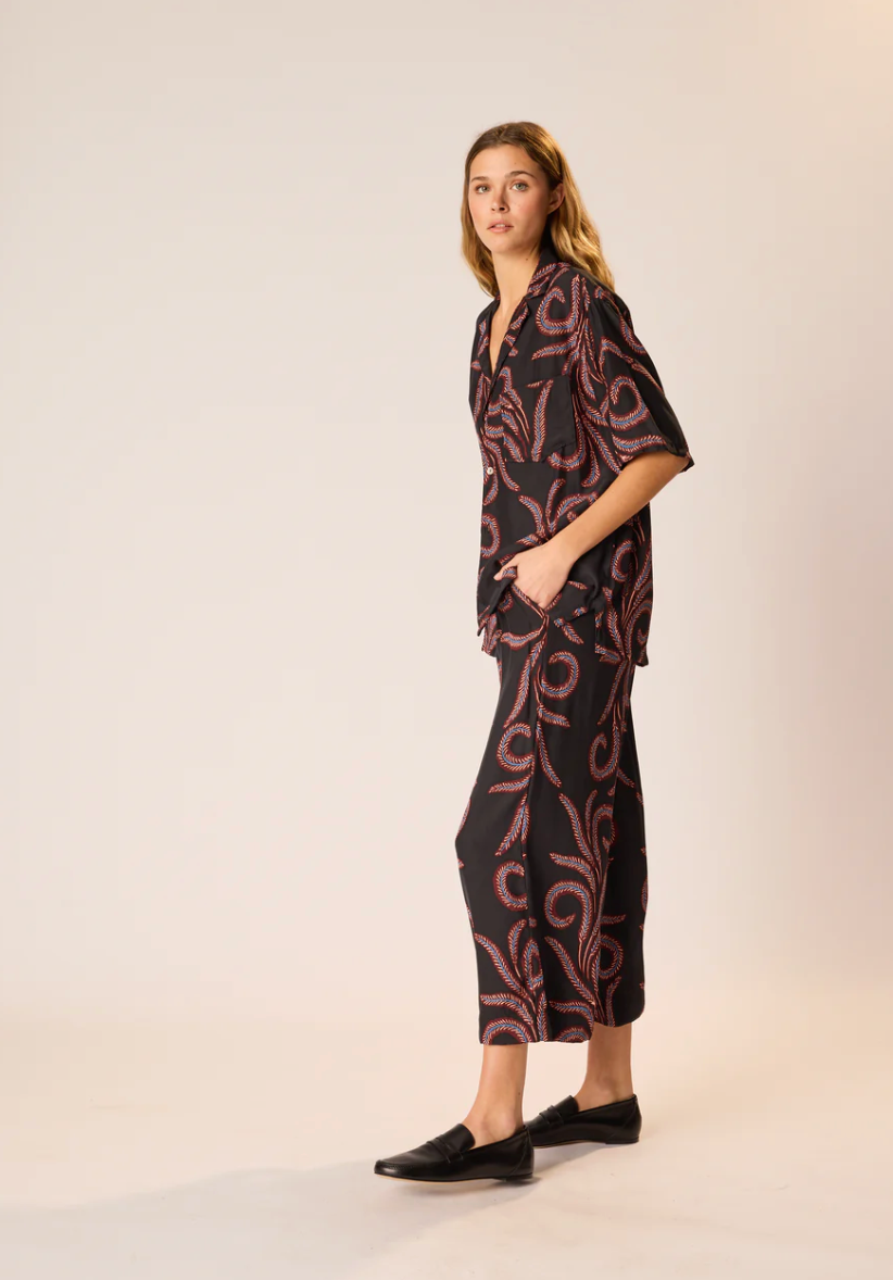 Woman wearing a black and red patterned outfit on a white background