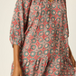Woman wearing a floral dress with a neutral background