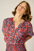 V-neck blouse with shell buttons. Short sleeves with button closure at cuff. Slightly pleated under collar to add body.