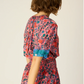 V-neck blouse with shell buttons. Short sleeves with button closure at cuff. Slightly pleated under collar to add body.