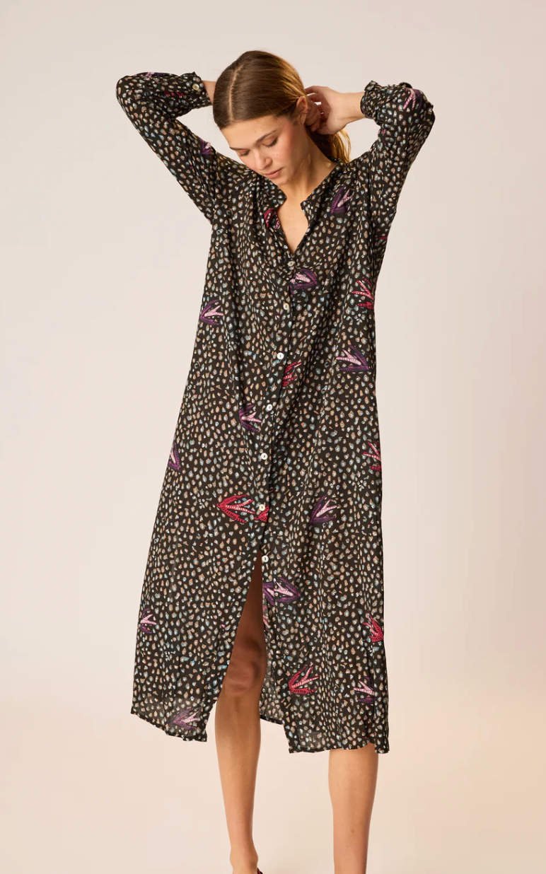 Woman wearing a black floral patterned dress on a beige background