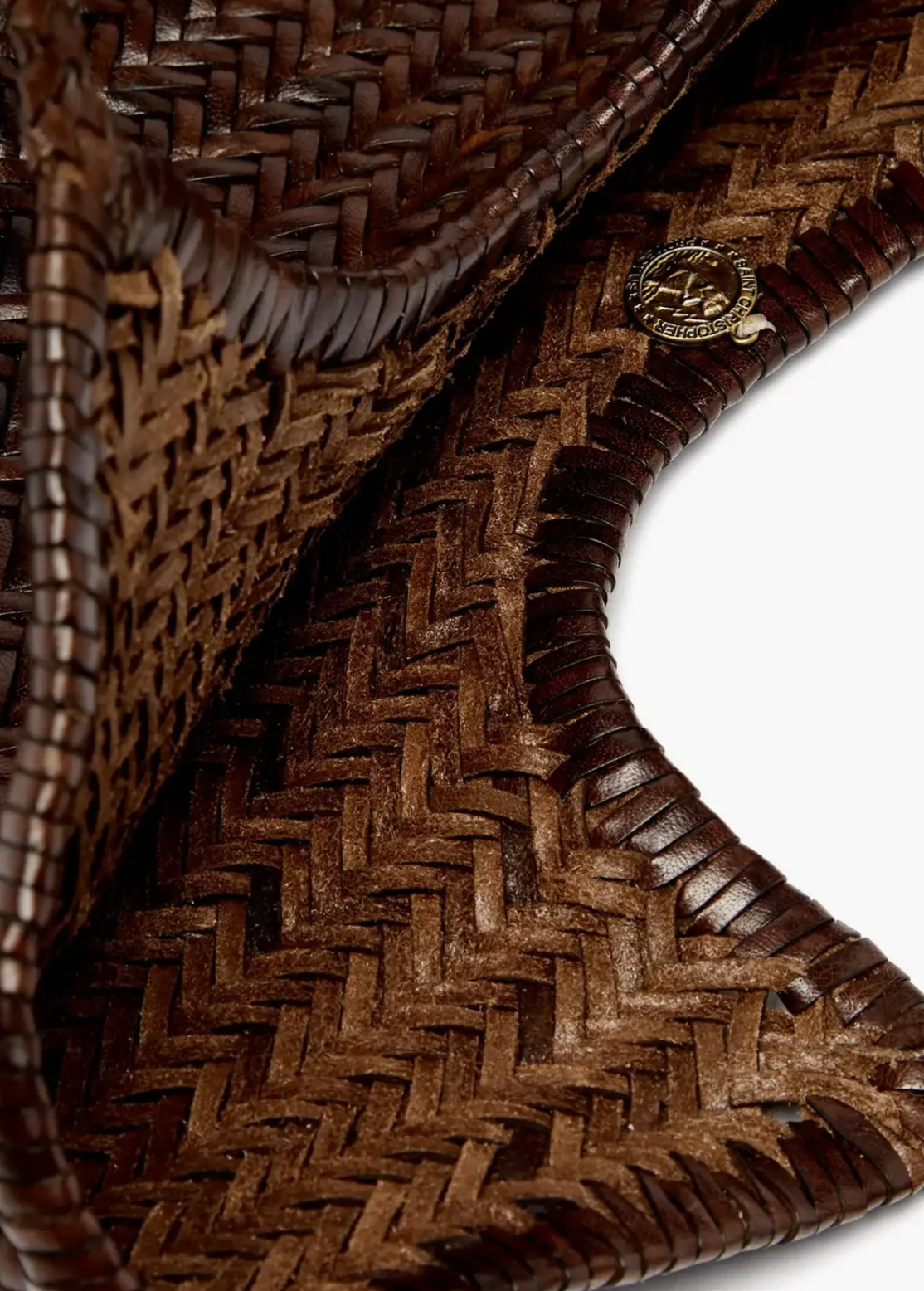 Close-up of a woven brown leather product with a brand logo.
