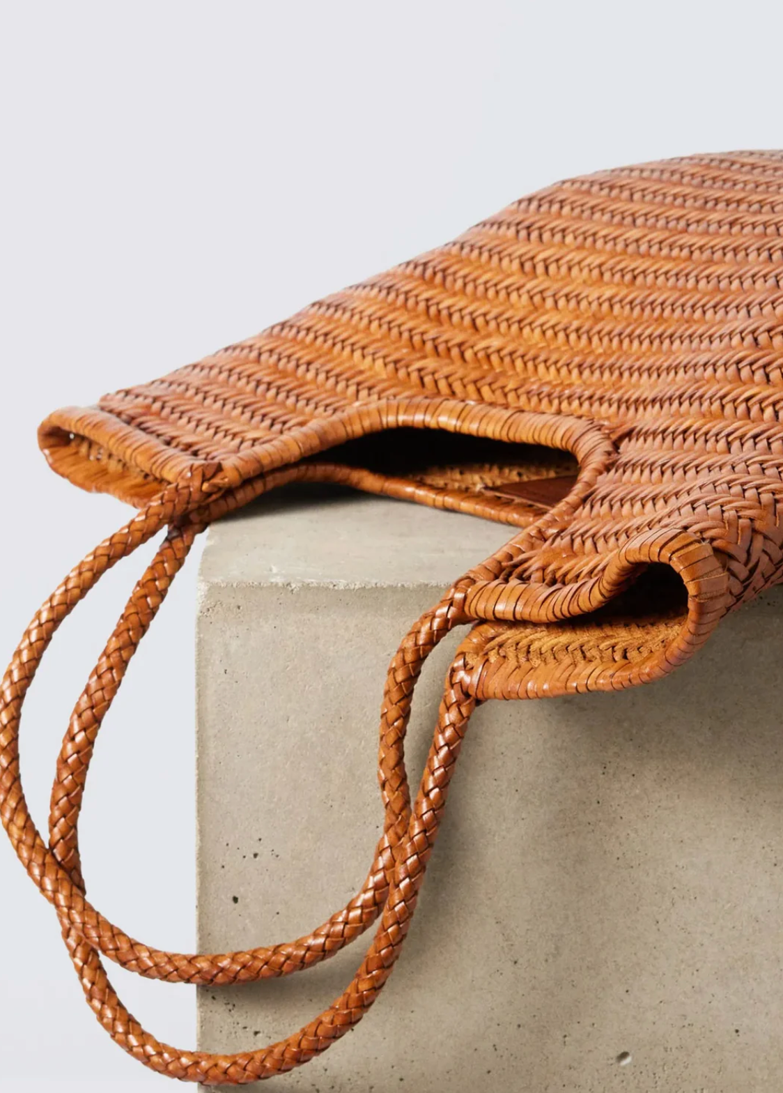 Woven bag with a strap on a light gray background