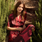 Woman in a red dress sitting among green plants